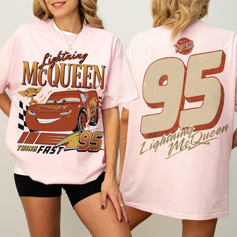 May include: Pale pink t-shirt with Lightning McQueen graphics. The front shows McQueen with text "Lightning McQueen", "Think Fast", and the number "95". The back has a large "95" and "Lightning McQueen" text.