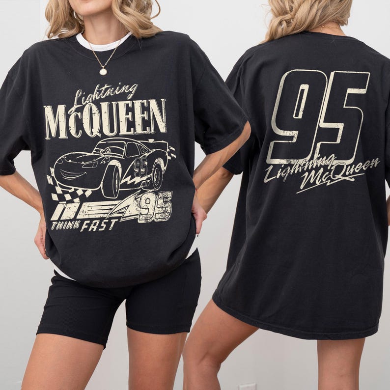 Puede incluir: Camiseta negra con gr&aacute;ficos de Lightning McQueen. La parte delantera muestra el coche con el texto "Lightning McQueen", "95" y "Think Fast". La parte trasera de la camiseta tiene un gran "95" y el texto "Lightning McQueen". La camiseta se usa con pantalones cortos negros.