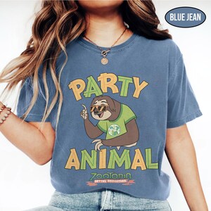 May include: Blue jean colored t-shirt with the words "PARTY ANIMAL" in orange and green block letters. A cartoon sloth wearing sunglasses and a green shirt is in the center. The text "ZOOTOPIA BETTER TOGETHER" is at the bottom.