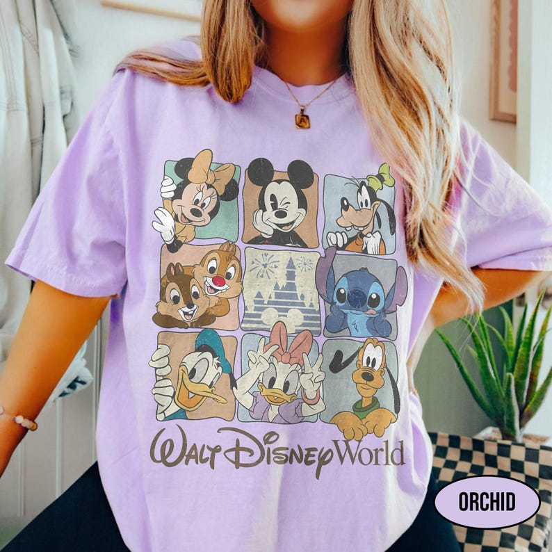 May include: A light purple t-shirt featuring a grid of nine squares with illustrations of various cartoon characters, including Mickey Mouse, Minnie Mouse, Goofy, Stitch, Donald Duck, Daisy Duck, Pluto, Chip, and Dale, with the text Walt Disney World.