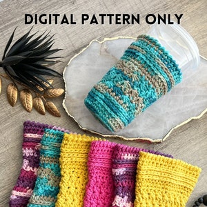 May include: Five crocheted cup cozies in various colors, including yellow, pink, purple, and teal. The cozies are stacked on top of each other, with the yellow cozy at the bottom and the teal cozy at the top. The cozies are made with a simple stitch pattern and have a textured look.