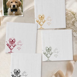 May include: Four square white napkins featuring a golden retriever puppy illustration inside a martini glass. The text reads Let's Pawty! LOVE, REGGIE. The graphic is printed in four different colours: gold, maroon, sage green, and black.