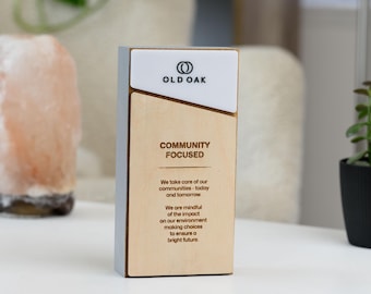 May include: A wooden block with the text "OLD OAK" and "COMMUNITY FOCUSED". The block has a white top and grey sides. The text "We take care of our communities - today and tomorrow" is also visible.