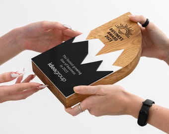 May include: A wooden award plaque with a black and white design. The plaque has the text "Business Award 2023" and "The fastest growing line of business in 2023" and the company name "ideagroup".
