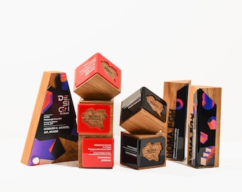May include: A set of five wooden awards with red and black accents. The awards feature the text "NOMA" and "NOMA PGH".