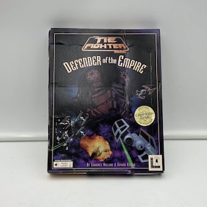 Op de afbeelding: Een rechthoekige videospeldoos voor Star Wars TIE Fighter: Defender of the Empire. De zwarte hoes toont een ruimtegevecht met TIE-fighters, een gele explosie en de speltitel in witte en oranje tekst met een gouden sticker.