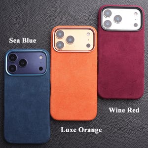 May include: Three phone cases in sea blue, luxe orange, and wine red. Each case has a textured finish and a camera cutout. The sea blue case has a blue camera ring, the luxe orange case has a gold camera ring, and the wine red case has a silver camera ring.