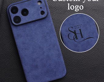 Può includere: Custodia per telefono blu navy con una texture simile alla pelle scamosciata. La custodia ha un ritaglio per la fotocamera ed è visibile il testo "Custom your logo". Una toppa circolare mostra un logo con il testo "SAMIRA HADID" e le iniziali "SH".