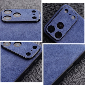 K&ouml;nnte beinhalten: Nahaufnahme einer blauen Handyh&uuml;lle mit einer strukturierten, Wildleder-&auml;hnlichen Oberfl&auml;che. Die H&uuml;lle hat einen schwarzen Rand und Aussparungen f&uuml;r die Kameralinsen. Das Design ist modern und elegant und bietet Schutz und Stil.