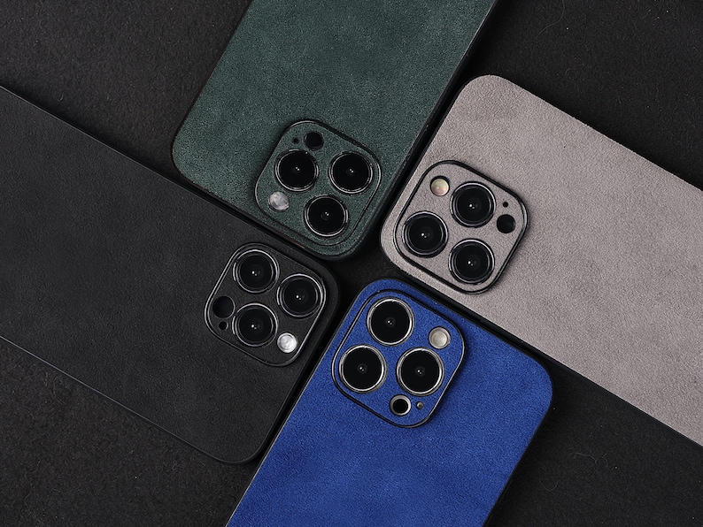 May include: Four different coloured phone cases with a camera lens cutout. The cases are green, grey, black, and blue.