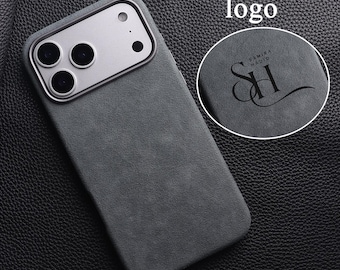 Può includere: Una custodia per telefono grigio scuro con un modulo fotocamera argentato. La custodia ha una superficie strutturata e le parole "Custom your logo" sono in alto. Un inserto circolare mostra un logo con il testo "SAMIRA HADID" e le iniziali "SH".