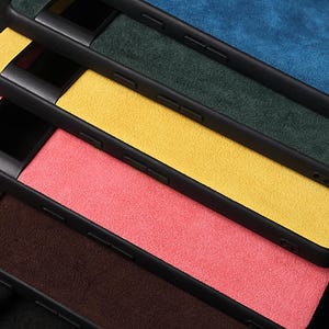 Pode incluir: Quatro capas para telem&oacute;vel empilhadas umas sobre as outras. As capas s&atilde;o feitas de um material macio, semelhante a camur&ccedil;a, e est&atilde;o dispon&iacute;veis em quatro cores: azul, verde, amarelo e rosa.