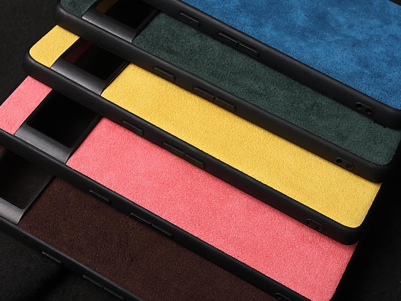 Pode incluir: Quatro capas para telem&oacute;vel empilhadas umas sobre as outras. As capas s&atilde;o feitas de um material macio, semelhante a camur&ccedil;a, e est&atilde;o dispon&iacute;veis em quatro cores: azul, verde, amarelo e rosa.