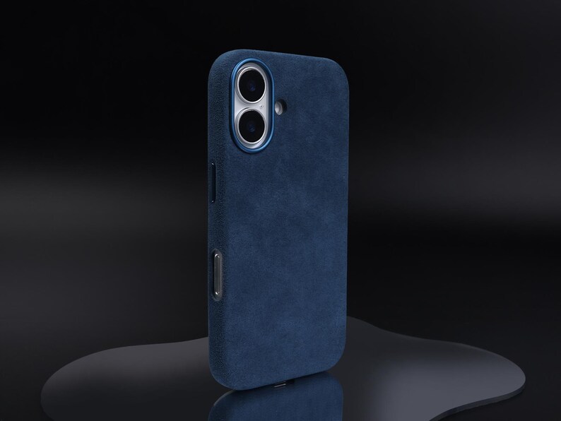 May include: A dark blue phone case with a textured suede finish. The case has a raised camera bump with two lenses.