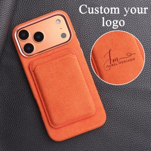 May include: Orange phone case with a cardholder. The case has a custom logo option. The phone case is shown on a dark surface. The case has a camera cutout and a cardholder on the back.