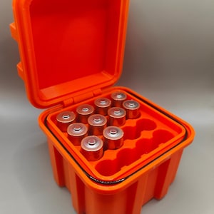 May include: Orange plastic storage case with a black rubber seal, open to reveal compartments for holding batteries. The case is filled with AA batteries.