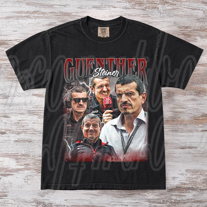 May include: Black t-shirt featuring a graphic of Guenther Steiner, with his name in red and white. The design includes multiple images of Steiner in various poses. The shirt is made of a soft, comfortable material.