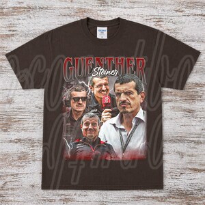 May include: A brown t-shirt featuring a graphic of Guenther Steiner, with multiple images of him and the text "GUENTHER Steiner" in red and white. The shirt has a crew neck and short sleeves.