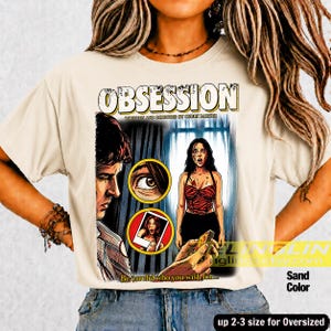 K&ouml;nnte beinhalten: Sandfarbenes T-Shirt mit einem Filmplakat-Design. Die Grafik zeigt das Wort "OBSESSION" &uuml;ber einer Szene mit einem Mann, einer Frau und dem Text "Be careful who you wish for..." Das Shirt ist bis zu einer Gr&ouml;&szlig;e von 2-3 f&uuml;r Oversized-Passformen erh&auml;ltlich.