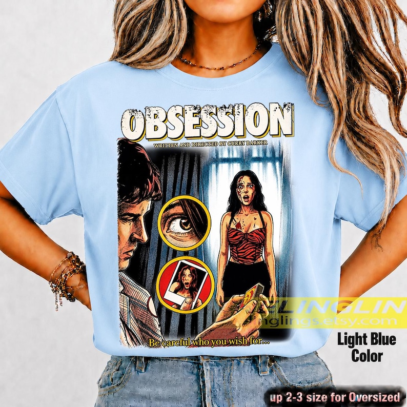 K&ouml;nnte beinhalten: Hellblaues T-Shirt mit einem Filmplakat-Design f&uuml;r "Obsession". Die Grafik zeigt Illustrationen eines Mannes, einer Frau und den Text "Be careful who you wish for...". Erh&auml;ltlich in bis zu 2-3 Gr&ouml;&szlig;en f&uuml;r &uuml;bergro&szlig;e Passformen.