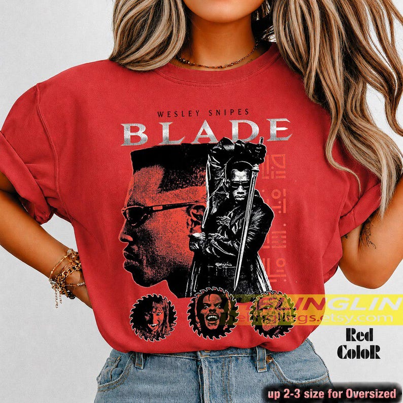 May include: A red t-shirt featuring a graphic print of Wesley Snipes as Blade. The design includes the text "WESLEY SNIPES BLADE" above a large portrait and a full-body figure holding a sword, with three smaller circular character portraits below.