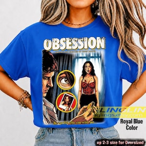 K&ouml;nnte beinhalten: K&ouml;nigsblaues T-Shirt mit einem Comic-Stil-Grafik. Die Grafik zeigt das Wort "OBSESSION" und den Text "WRITTEN AND DIRECTED BY GURRY BARNER". Das Design enth&auml;lt Illustrationen eines Mannes, einer Frau und anderer Elemente. Der Text "Be careful who you wish for..." ist ebenfalls vorhanden.
