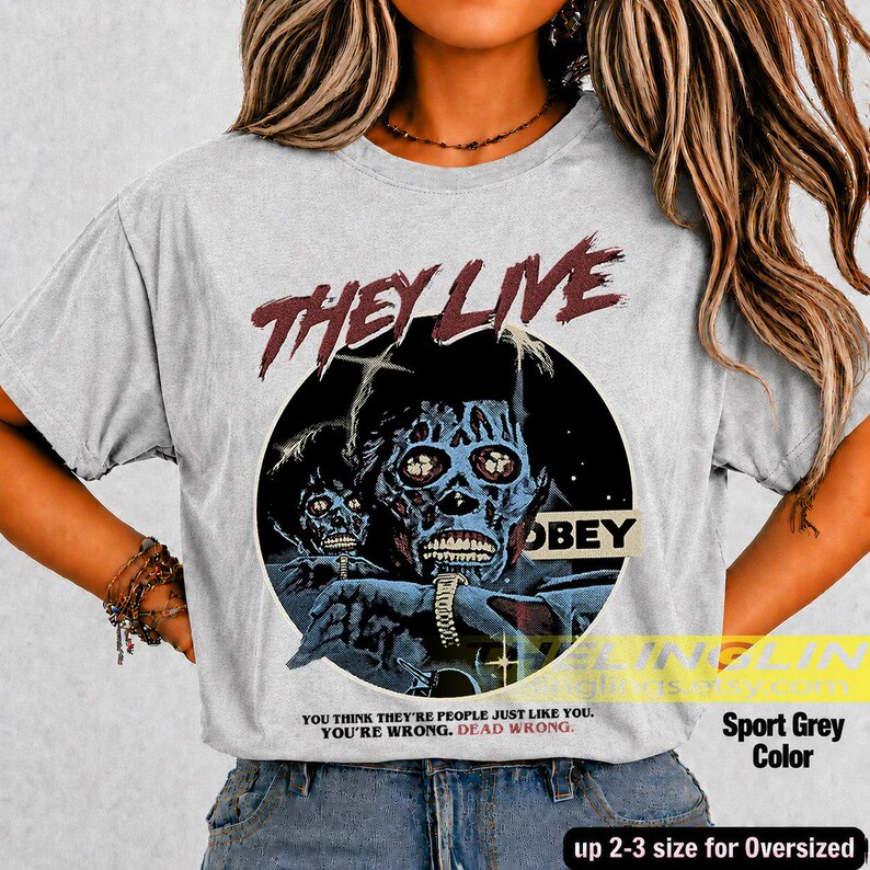 K&ouml;nnte beinhalten: Ein hellgraues T-Shirt mit einem Grafikdruck einer skelettartigen Figur mit dunkelblauer Haut und einer Armbanduhr. Der Text lautet THEY LIVE in Rot, OBEY in einem schwarzen Kasten und YOU THINK YOU ARE PEOPLE JUST LIKE YOU. YOU ARE WRONG. DEAD WRONG.