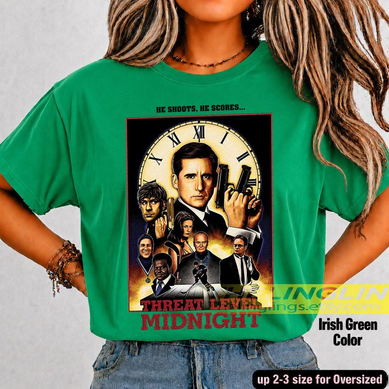 May include: An Irish green t-shirt featuring a graphic print of the movie poster for Threat Level Midnight. The design includes a large clock face, multiple character portraits, and the text HE SHOOTS, HE SCORES and THREAT LEVEL MIDNIGHT.