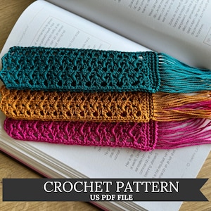 May include: Three crocheted bookmarks with fringe, in teal, orange, and pink, are displayed on a book. The text "CROCHET PATTERN US PDF FILE" is at the bottom of the image.