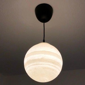 Eine kugelförmige Pendelleuchte die den Jupiter darstellt
