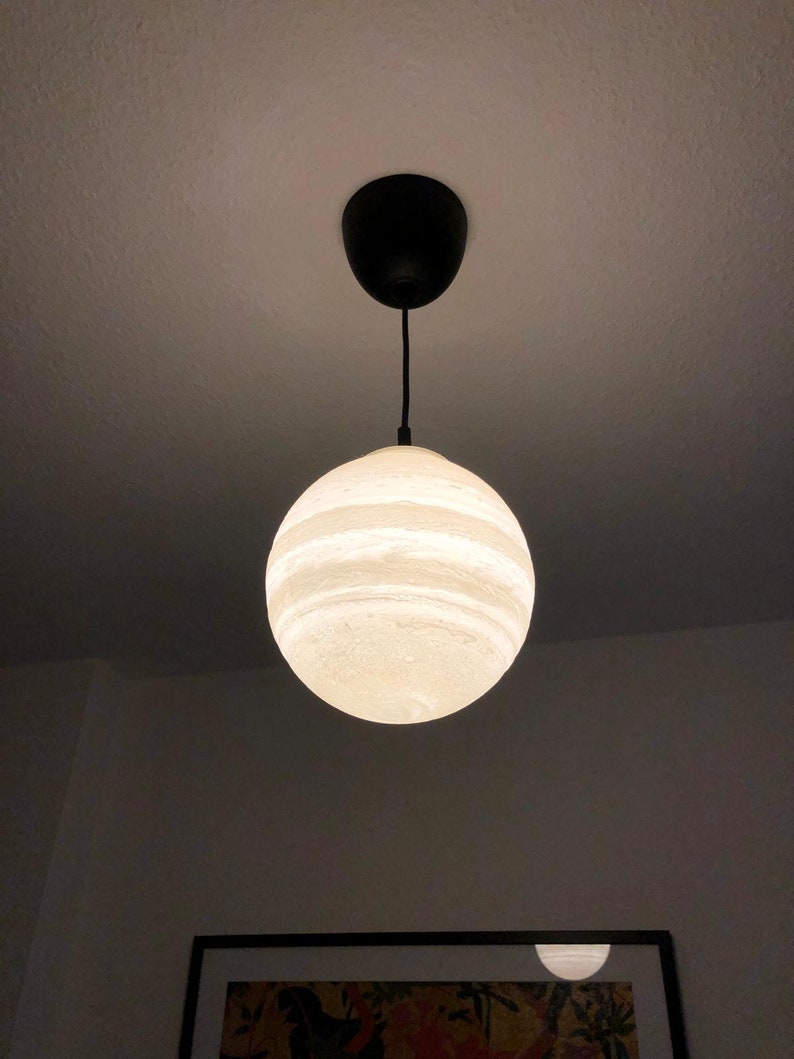 Eine kugelförmige Pendelleuchte die den Jupiter darstellt