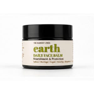 Könnte beinhalten: Ein schwarzer zylindrischer Tiegel mit The Radiant Ones Earth Daily Face Balm. Das cremefarbene Etikett zeigt grünen Text mit der Aufschrift earth und schwarzen Text mit DAILY FACE BALM, Nourishment & Protection, Tallow, Moringa, Argan, Rosehip, Raspberry.
