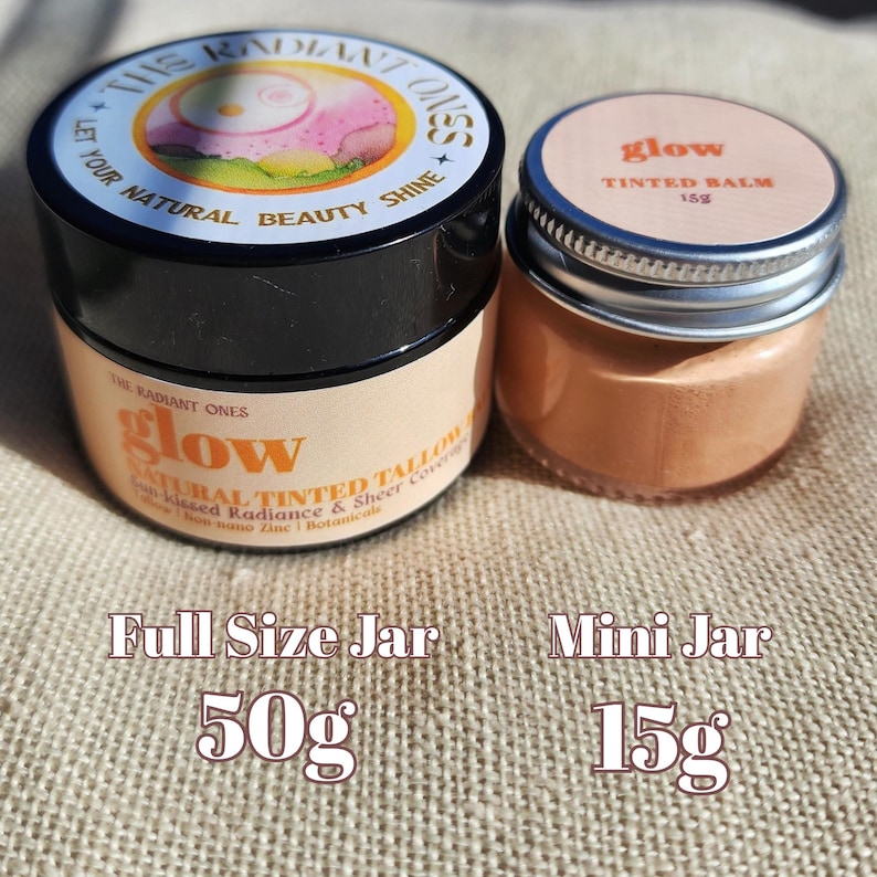 May include: A 50g full size jar and a 15g mini jar of The Radiant Ones glow natural tinted tallow. The larger jar has a black lid and a label reading Let Your Natural Beauty Shine. The smaller jar has a silver lid and a label reading glow tinted balm 15g.