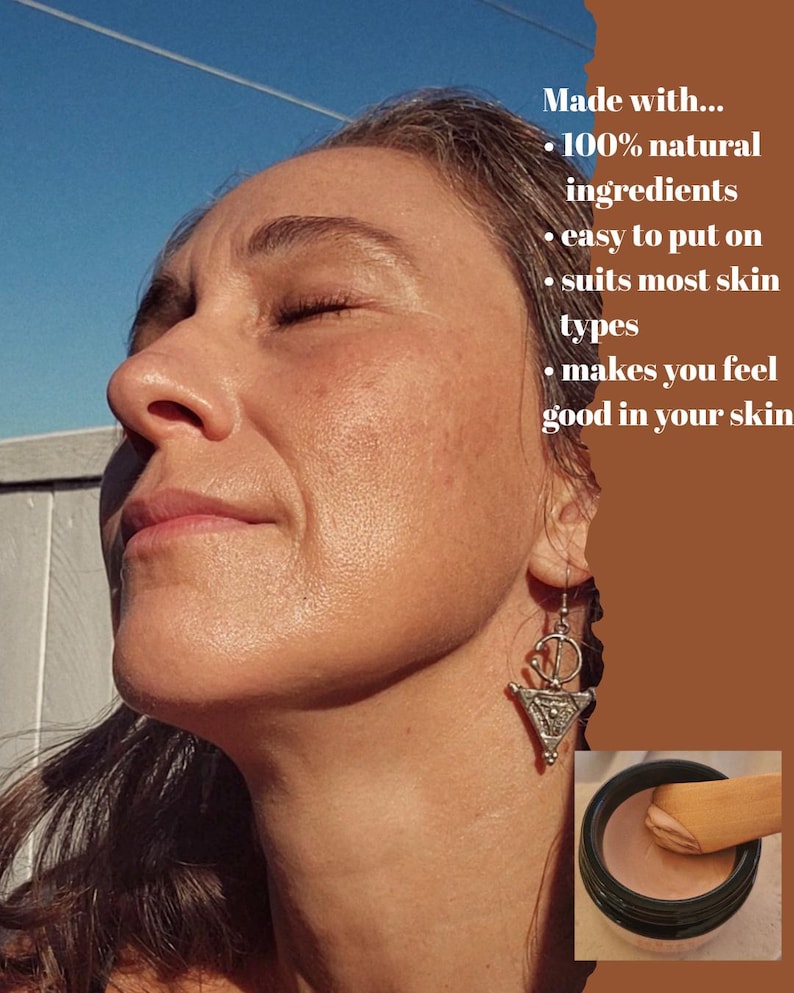 May include: A small black jar containing a light-toned cosmetic cream with a wooden applicator. The image includes text: Made with... 100% natural ingredients, easy to put on, suits most skin types, makes you feel good in your skin.