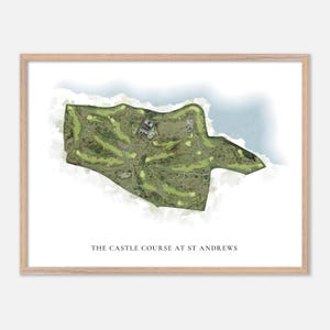 May include: A framed print featuring a watercolour map of The Castle Course at St Andrews. The golf course is depicted with green fairways, bunkers, and buildings. The text "THE CASTLE COURSE AT ST ANDREWS" is printed at the bottom of the image.