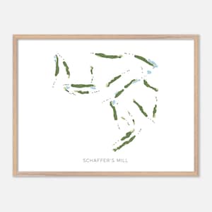 May include: A framed print featuring a golf course map with green fairways and blue water features on a white background. The text "SCHAFFER'S MILL" is printed in black at the bottom. The frame is a light wood color.