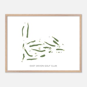 May include: A framed print featuring a green and white golf course map. The map shows the layout of the East Devon Golf Club. The print is in a light-colored wooden frame, suitable for wall decor.