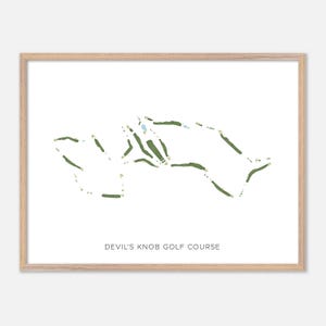 May include: A framed print featuring a golf course map. The course layout is depicted in green and white against a white background. The text "DEVIL'S KNOB GOLF COURSE" is printed in a simple font at the bottom of the image. The frame is a light wood color.