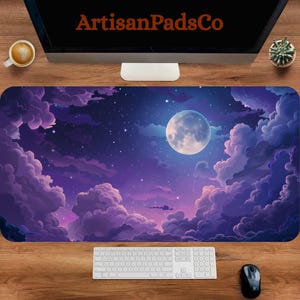 May include: A large rectangular desk mat featuring a vibrant night sky design with a full moon, stars, and fluffy purple clouds. The mat has the text "ArtisanPadsCo" at the top. A keyboard, mouse, and coffee cup are visible.