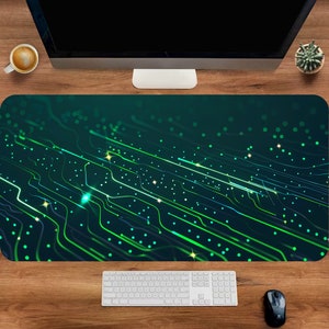 Op de afbeelding: Een groene en blauwe computermuismat met een printplaatontwerp. De muismat heeft een textuur en een donkergroene achtergrond met gloeiende groene lijnen.
