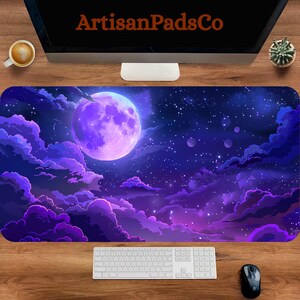 Può includere: Tappetino per scrivania con un design a cielo notturno, con una grande luna viola, nuvole e stelle. Il logo ArtisanPadsCo è visibile in alto. Una tastiera e un mouse sono in basso.