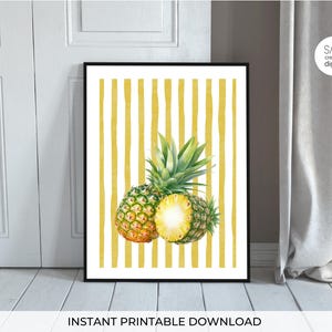 Peut inclure: Une affiche encadrée avec des ananas à l'aquarelle. L'image montre deux ananas entiers et un coupé en deux, sur un fond à rayures jaunes et blanches. Les mots "INSTANT PRINTABLE DOWNLOAD" sont en bas.