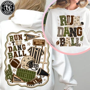 May include: A white hooded sweatshirt featuring a large graphic print with the text "RUN THE DANG BALL" in a patchwork style. The design includes football-themed illustrations like a helmet, a referee shirt, a field, and a pennant.