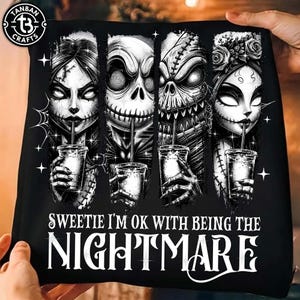 May include: A black t-shirt featuring a graphic print of four characters from The Nightmare Before Christmas, each holding a drink. The text below reads: SWEETIE I'M OK WITH BEING THE NIGHTMARE. The design includes spiderwebs and stars.
