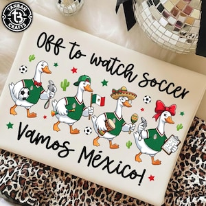 Pu&ograve; includere: Una superficie rettangolare bianca con il testo Off to watch soccer e Vamos M&eacute;xico. Il design include quattro oche animate che indossano maglie da calcio verdi, con accessori come un fischietto, una bandiera messicana, un sombrero e una lavagnetta.