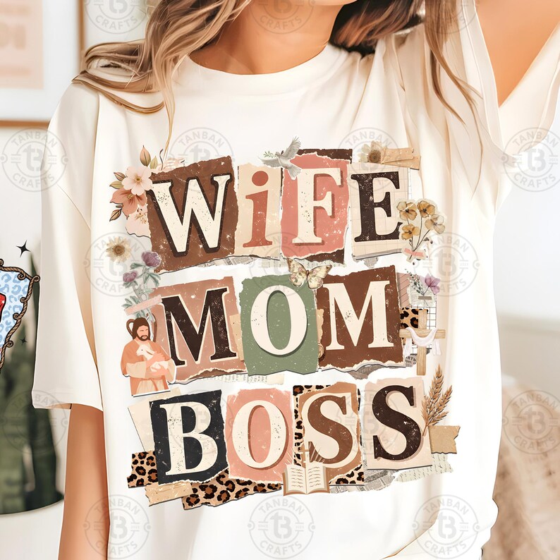 May include: Cream-colored t-shirt with the words "WIFE MOM BOSS" in a collage style. The design incorporates floral elements, a butterfly, and a leopard print pattern. The shirt is a casual, everyday wear item.