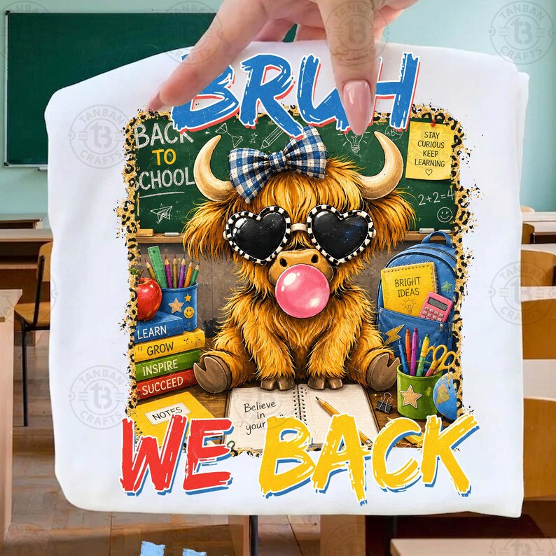 May include: A white t-shirt featuring a graphic of a fluffy highland cow wearing a blue plaid bow and heart-shaped sunglasses while blowing a pink bubble. The design includes school supplies, a chalkboard, and the text BRUH WE BACK.