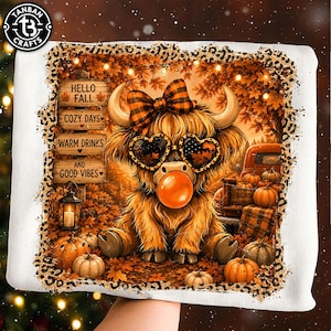 May include: A white sweatshirt featuring a graphic of a fluffy highland cow wearing a plaid bow and heart-shaped sunglasses while blowing an orange bubble. The design includes autumn leaves, pumpkins, and signs reading HELLO FALL COZY DAYS WARM DRINKS AND GOOD VIBES, all framed by a leopard print border.