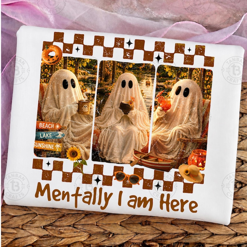 May include: White t-shirt with a whimsical design featuring three ghost figures enjoying leisure activities. The ghosts are depicted with black oval eyes and draped in white sheets. The text "Mentally I am Here" is printed in brown.
