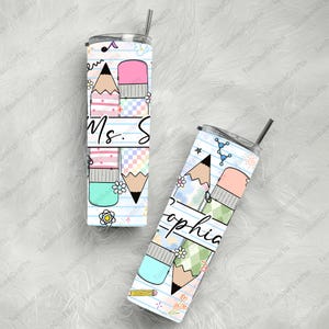 May include: Two stainless steel insulated tumblers with pencil and eraser designs. One tumbler has "Ms. S" printed on it, and the other has "Sophia" printed on it. The tumblers have a straw and a lid.
